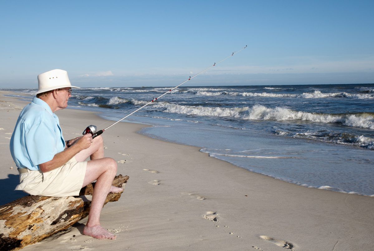 older man fishing on the beach